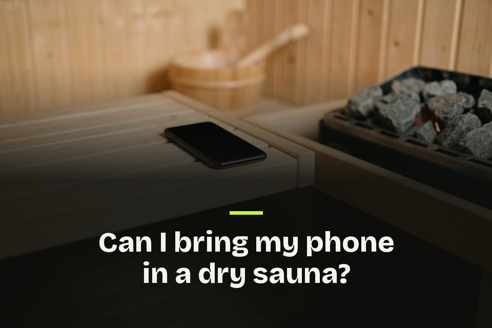 Can I bring my phone in a dry sauna The words "Can I bring my phone in a dry sauna?" over a photo of a phone near the hot stones of a dry sauna heater.