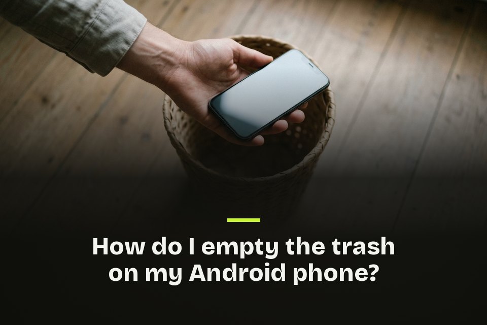 How do I empty the trash on my Android phone The words "How do I empty the trash on my Android phone?" over a picture of a hand holding a phone over a woven bin.