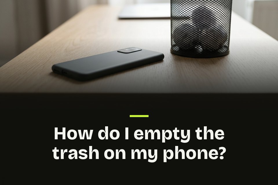 How do I empty the trash on my phone The words "How do I empty the trash on my phone?" over a picture of a phone on an oak desk beside a wire bin of paper.