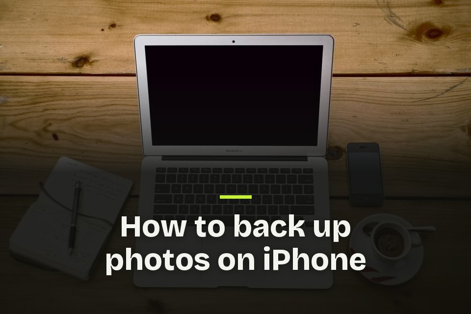 How to back up photos on iPhone The words "How to back up photos on iPhone" over a photo of a laptop, phone, notebook and coffee cup on a wooden table.