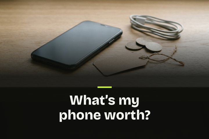 The words "What's my phone worth?" over a used phone on an oak desk beside a blank price tag, coins and a cable.